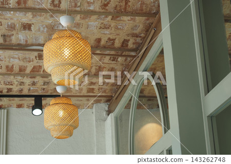 Lighting fixtures hang from the ceiling in a cafe interior Lighting fixtures hang from the ceiling in a cafe interior 143262748