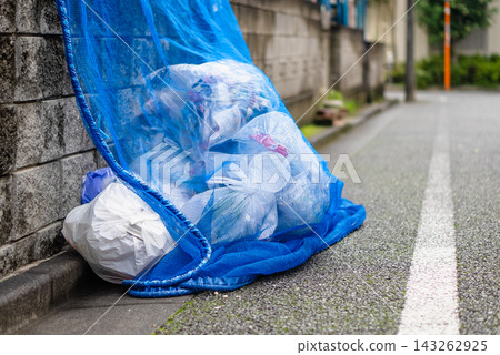 Japanese household garbage bags covered with blue crow-repellent netting. Japanese household garbage bags covered with blue crow-repellent netting. 143262925