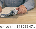 Person Reviewing Business Documents at Desk 143263471