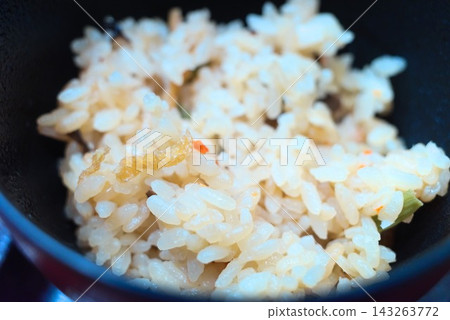 A table setting image featuring a classic Japanese dish: mixed rice with vegetables served in a bowl. A table setting image featuring a classic Japanese dish: mixed rice with vegetables served in a bowl. 143263772
