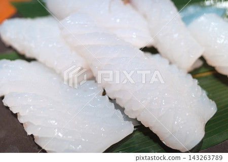 特寫鏡頭展現了海鮮料理和日本料理,圖中是擺放在竹葉上的新鮮魷魚刺身。 特寫鏡頭展現了海鮮料理和日本料理,圖中是擺放在竹葉上的新鮮魷魚刺身。 143263789