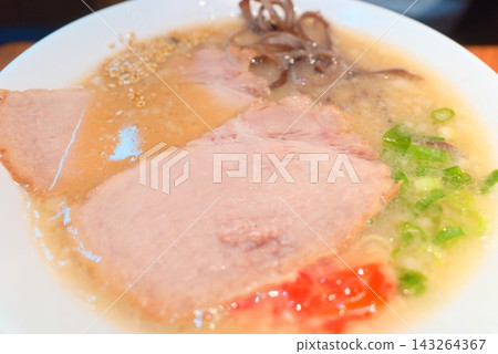 Hakata-style tonkotsu ramen topped with char siu pork, wood ear mushrooms, and pickled ginger. Hakata-style tonkotsu ramen topped with char siu pork, wood ear mushrooms, and pickled ginger. 143264367