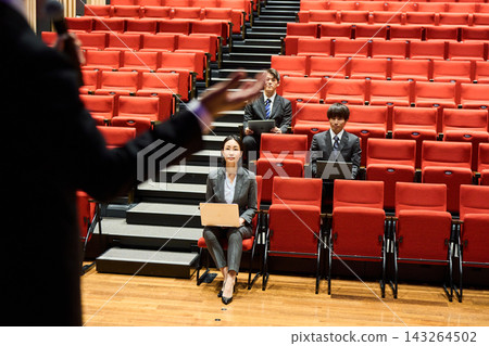 Business professionals, both male and female, listen intently to a presentation at a lecture. Business professionals, both male and female, listen intently to a presentation at a lecture. 143264502