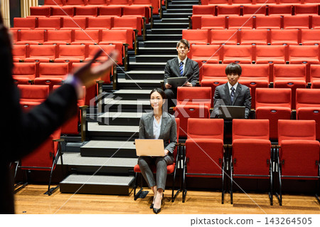 Business professionals, both male and female, listen intently to a presentation at a lecture. Business professionals, both male and female, listen intently to a presentation at a lecture. 143264505