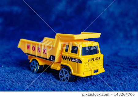 Toy dump truck on blue background for play and learning activities Toy dump truck on blue background for play and learning activities 143264706