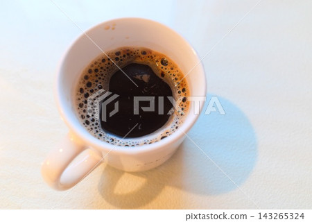 一杯盛在白色杯子裡的熱咖啡,一張寬敞的桌子。 一杯盛在白色杯子裡的熱咖啡,一張寬敞的桌子。 143265324