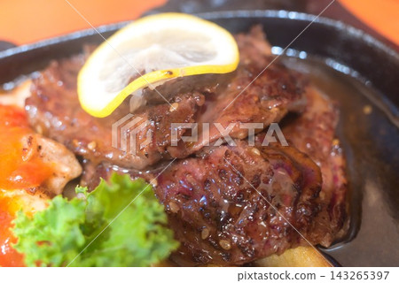 Enjoy a juicy steak and colorful side dishes at a restaurant. Enjoy a juicy steak and colorful side dishes at a restaurant. 143265397
