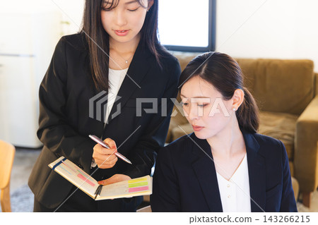 一位女商人打開筆記本，向某人請教。 143266215