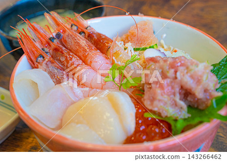 A Hokkaido-style seafood rice bowl topped with sweet shrimp, scallops, salmon roe, and minced tuna. A Hokkaido-style seafood rice bowl topped with sweet shrimp, scallops, salmon roe, and minced tuna. 143266462