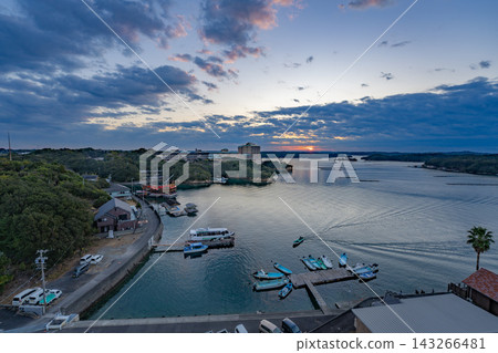 A sunset view of a Japanese bay overlooking aquaculture rafts and a harbor. A sunset view of a Japanese bay overlooking aquaculture rafts and a harbor. 143266481