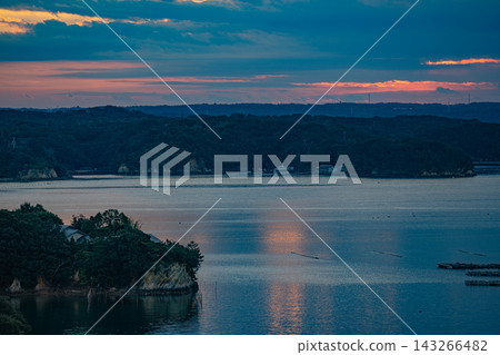 A quiet bay at dusk, dotted with aquaculture rafts. A quiet bay at dusk, dotted with aquaculture rafts. 143266482