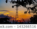 夕陽西下，橘色的天空映襯著輸電塔和高壓電線的輪廓。 143266516