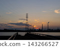 夕陽西下，電力傳輸塔和工廠的輪廓漂浮在水面上。 143266527
