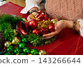 Woman Creating a Festive Christmas Ornament Centerpiece 143266644