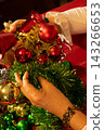Hands Decorating Christmas Tree With Red and Gold Ornaments 143266653