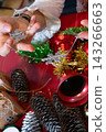 Hands Arranging Christmas Ornaments and Festive Decorations 143266663