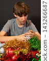 Young Man Making a Snowflake Christmas Ornament 143266687