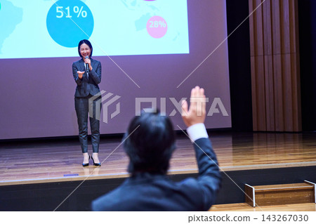 一位女主持人正在回答現場一位舉手的參與者的問題。 一位女主持人正在回答現場一位舉手的參與者的問題。 143267030