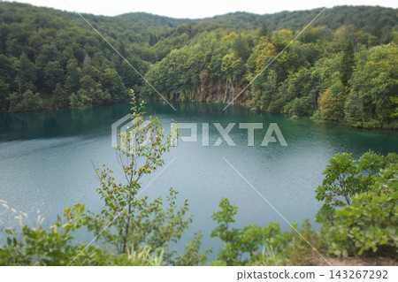 High-angle view of the vibrant blue waters and lush forested shores of Plitvice Lakes National Park, Croatia High-angle view of the vibrant blue waters and lush forested shores of Plitvice Lakes National Park, Croatia 143267292