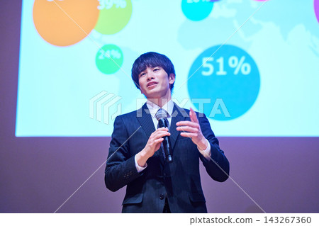 A young business person giving a presentation at a seminar, using data to support their presentation. A young business person giving a presentation at a seminar, using data to support their presentation. 143267360