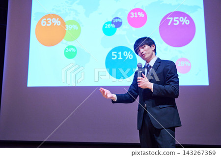 A young business person giving a presentation at a seminar, using data to support their presentation. A young business person giving a presentation at a seminar, using data to support their presentation. 143267369