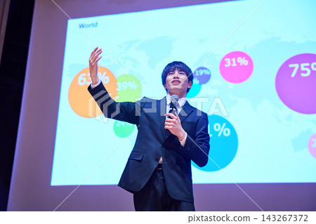 A young business person giving a presentation at a seminar, using data to support their presentation. 143267372
