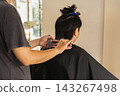 Professional hairstylist cutting hair with scissors in hair salon. 143267498