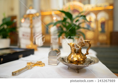 Golden liturgical set with a cross, pitcher, and ornate tray Golden liturgical set with a cross, pitcher, and ornate tray 143267989