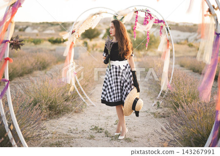beautiful girl in a retro dress posing on a lavender field with decorations beautiful girl in a retro dress posing on a lavender field with decorations 143267991
