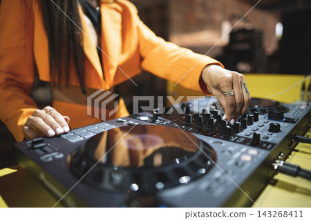 a DJ plays music on a controller at a party a DJ plays music on a controller at a party 143268411