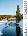 Winter view of the Vydra River flowing through the Modrava valley in Sumava National Park, Czech Republic, with warm sunrise light illuminating the snowy forest and landscape. 143268556