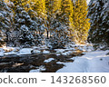 Winter view of the Vydra River flowing through the Modrava valley in Sumava National Park, Czech Republic, with warm sunrise light illuminating the snowy forest and landscape. 143268560