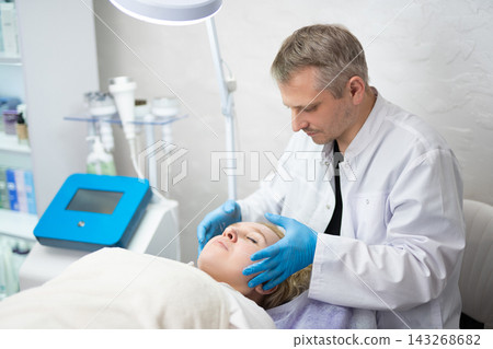 girl at a cosmetologist man during treatment procedures girl at a cosmetologist man during treatment procedures 143268682