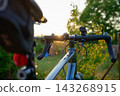 Gravel bike with handlebars and rear and front bicycle lights at sunset 143268915