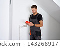 Electrician holding electrical boxes for wall sockets 143268917