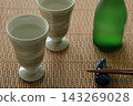桌上並排擺放著兩個清酒杯，讓人聯想到日本傳統的清酒形象。 143269028