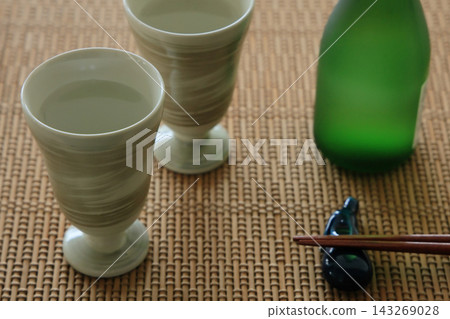 桌上並排擺放著兩個清酒杯,讓人聯想到日本傳統的清酒形象。 桌上並排擺放著兩個清酒杯,讓人聯想到日本傳統的清酒形象。 143269028