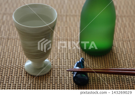 晚上享用飲品的餐桌擺設:清酒杯、清酒瓶和筷子。 晚上享用飲品的餐桌擺設:清酒杯、清酒瓶和筷子。 143269029