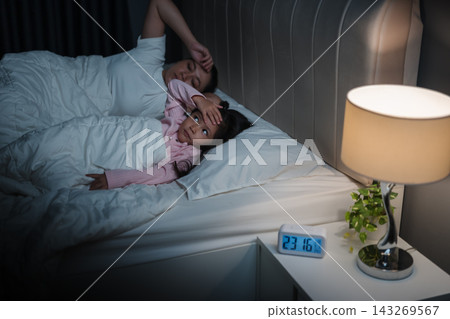 tired mother and preschool child girl having trouble sleeping in bed late at night, insomnia concept tired mother and preschool child girl having trouble sleeping in bed late at night, insomnia concept 143269567