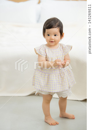 一位母親牽著她一歲女兒的手。 一位母親牽著她一歲女兒的手。 143269811