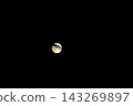 Full Moon Partially Obscured by Thin Wispy Clouds Against a Deep Black Night Sky Background 143269897