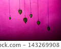 Groundcherry Pods Hanging on Thin Threads Against a Vibrant Magenta Pink Textured Backdrop 143269908