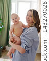 Happy mother holding her cute baby boy in bedroom close up 143270028