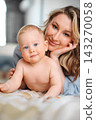 Cute baby lying on bed and looking at camera 143270058
