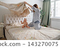 Cheerful mother making bed and playing with her laughing baby boy 143270075