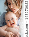 Close up portrait of happy laughing baby with mom 143270082