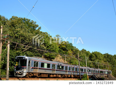 這是神戶電氣鐵道青線的一列火車，行駛在藍天綠樹環繞的風景中。 143272849