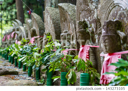 Stone Buddha statues wearing aprons lined up in a temple Stone Buddha statues wearing aprons lined up in a temple 143273105