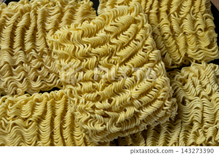 Close-up of raw instant wavy noodles stacked together Close-up of raw instant wavy noodles stacked together 143273390