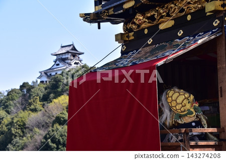 日本愛知縣犬山祭:犬山城天守閣和盛開的櫻花;一名身穿金色內衣的男孩在花車上敲著小鼓。 日本愛知縣犬山祭:犬山城天守閣和盛開的櫻花;一名身穿金色內衣的男孩在花車上敲著小鼓。 143274208